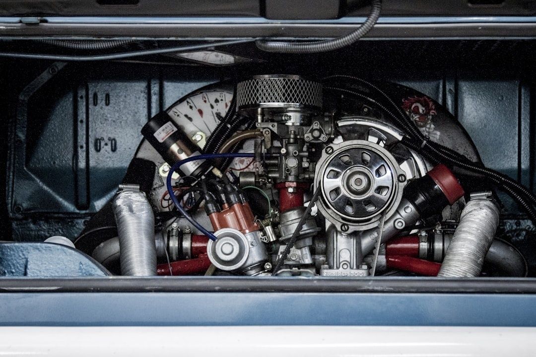 Open motorruimte met zichtbare carburateur, ontsteking en riemaandrijving
